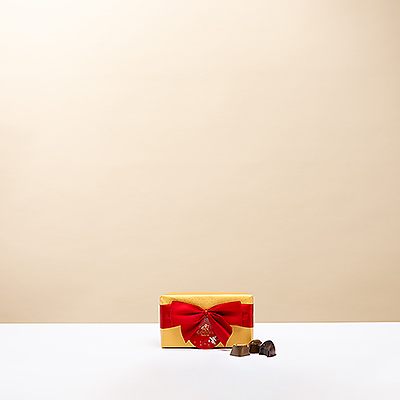 The iconic Godiva Gold Ballotin is wrapped up for the holidays with a beautiful hand-tied red ribbon and festive gift tag.