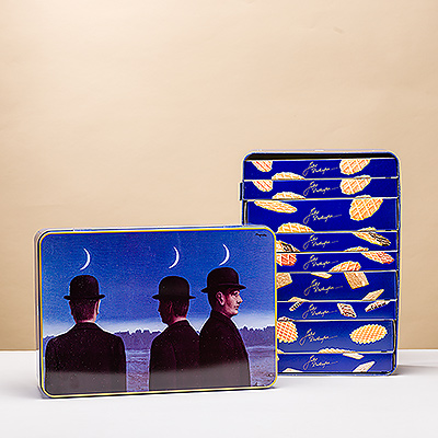 Disfrute de los mejores sabores belgas y del arte juntos en un regalo único. La famosa Biscuiterie belga Jules Destrooper presenta sus deliciosas y crujientes galletas en una lata de almacenamiento con una obra maestra de René Magritte.